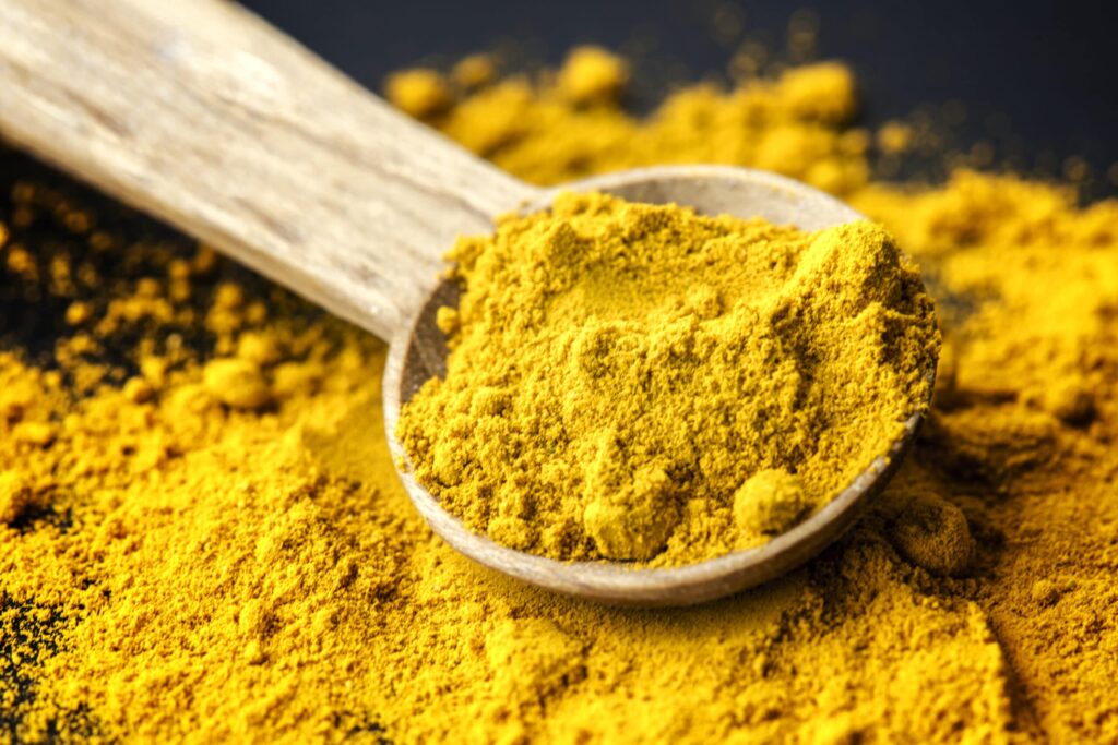 curcumin powder with wooden spoon