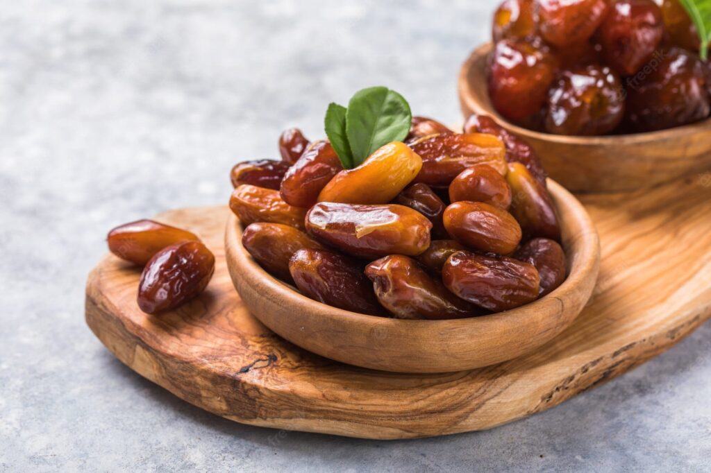 Medjool dates or dates fruit in wooden bowl  